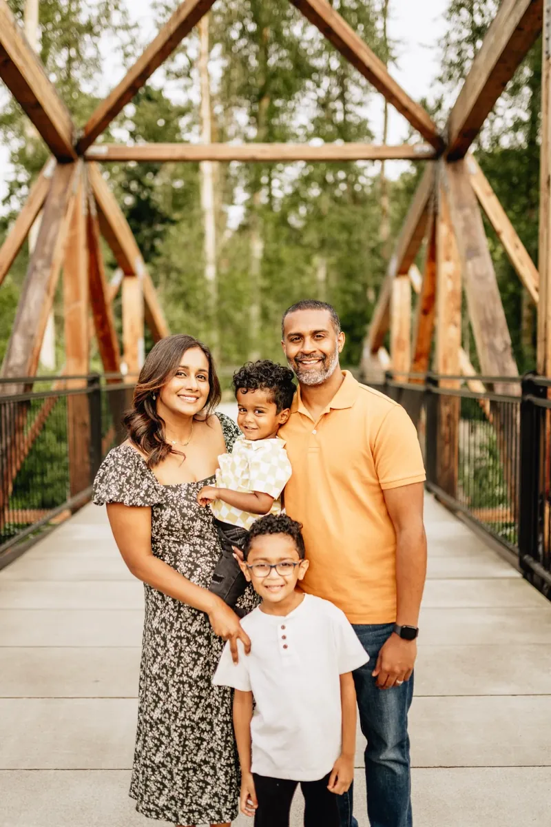 Family of four together on a wooden bridge