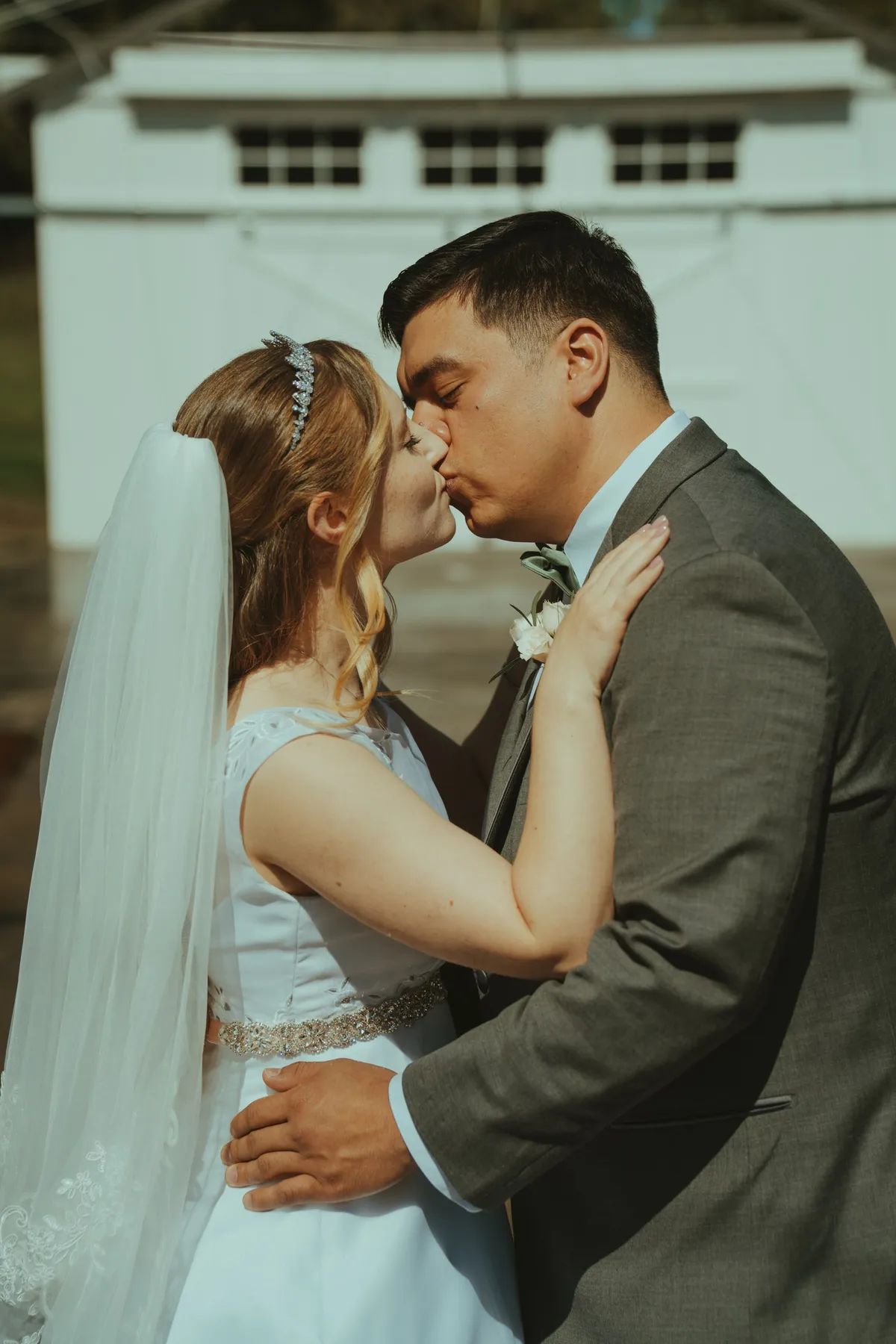 Bride and groom first kiss at outdoor wedding ceremony