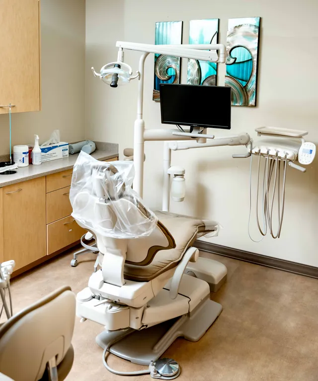 Dental treatment room with the patient chair, overhead light and monitor