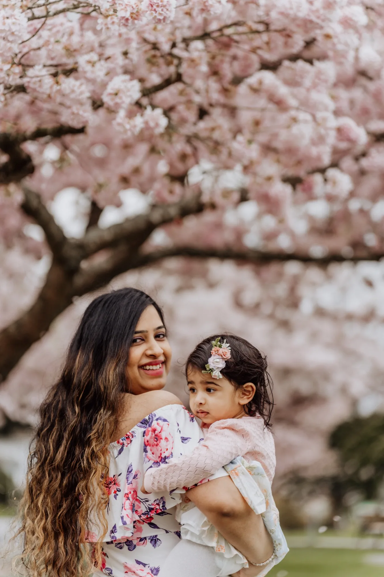 Mother and daughter laughing together under cherry blossoms in Lake Stevens