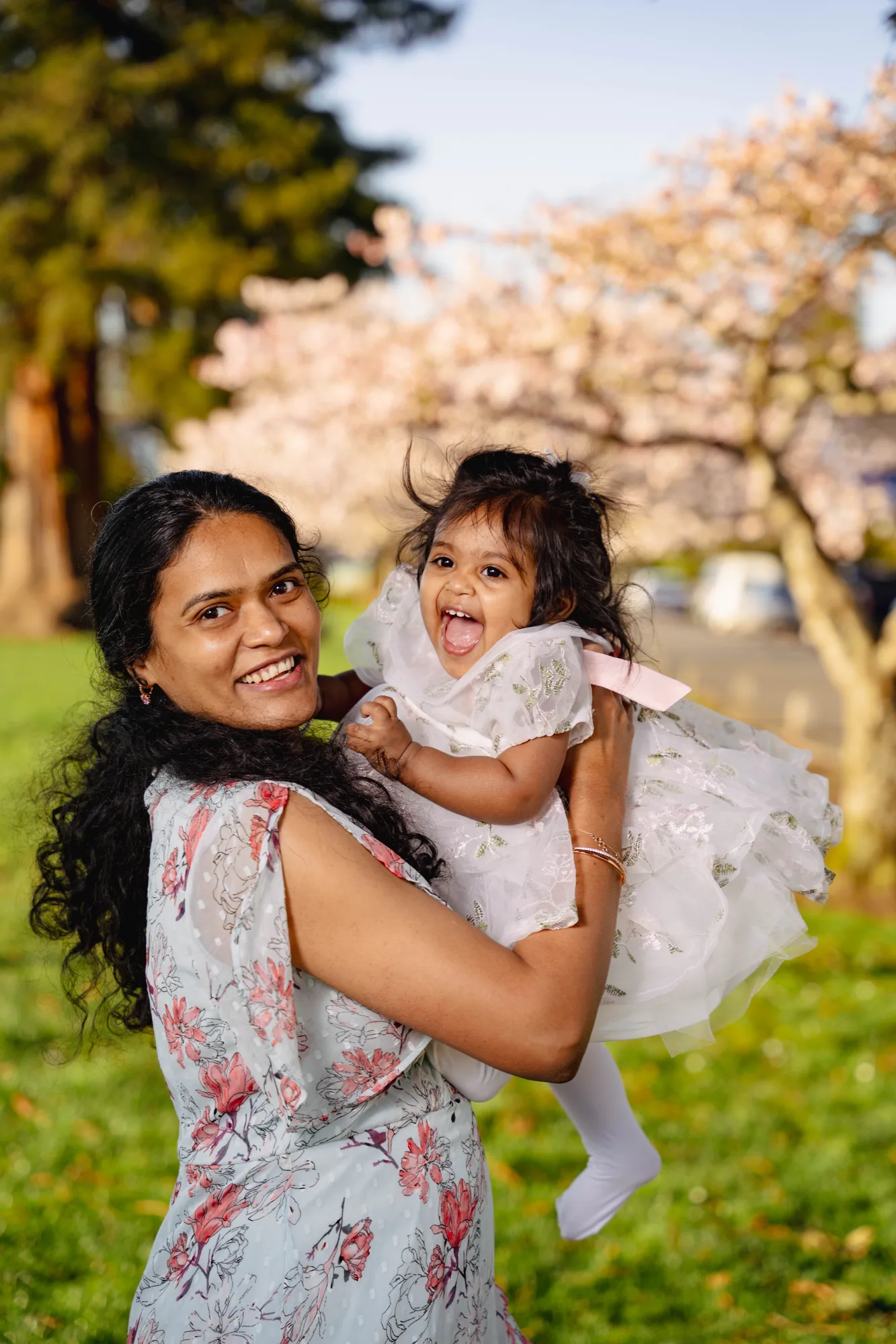 Mother and daughter laughing during cherry blossom family session in Snohomish County