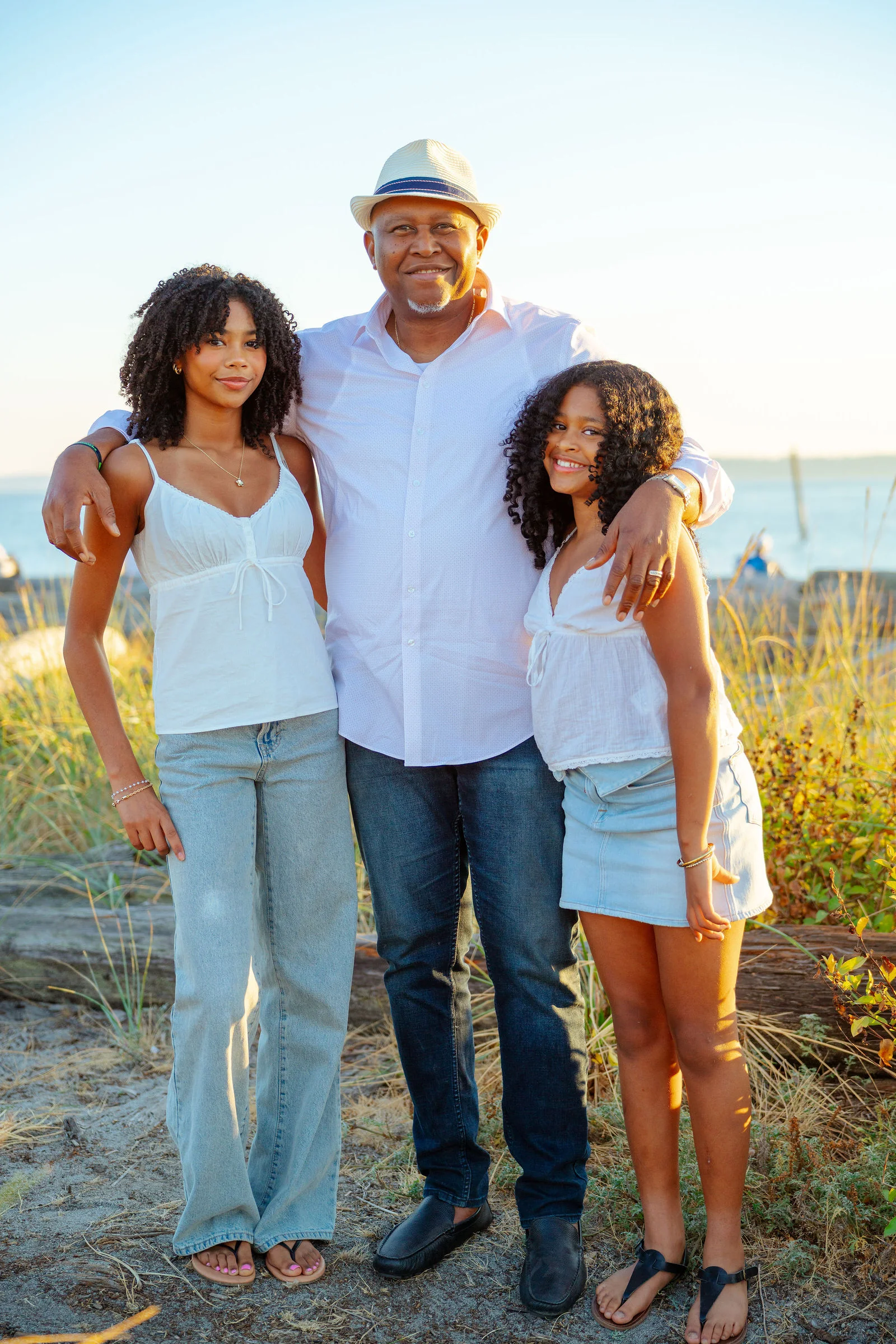 Father with his two daughters on the beach at sunset