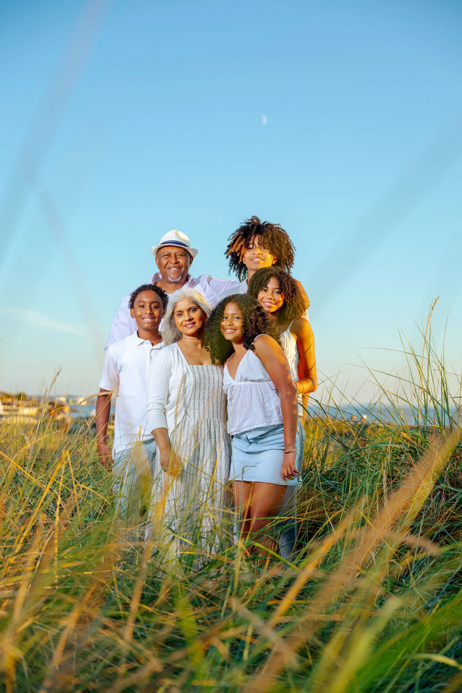 Family gathered in the dune grass at golden hour