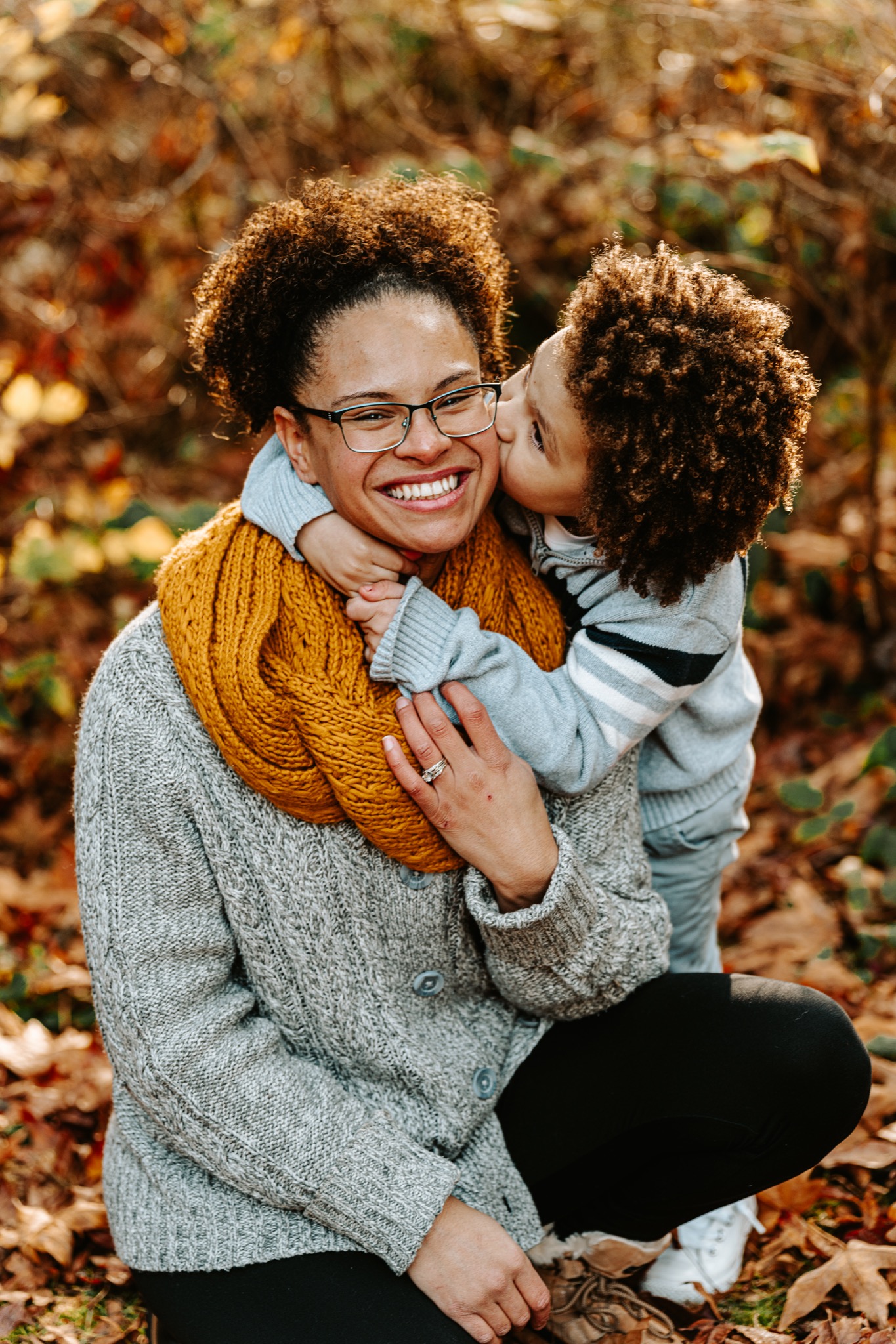 Son giving mom a kiss during autumn family session in Snohomish County