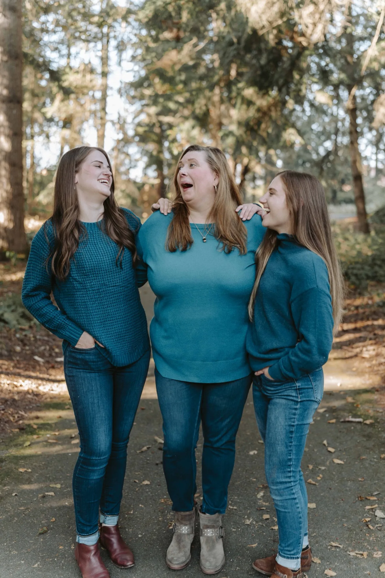 Mother and daughters laughing together in the forest