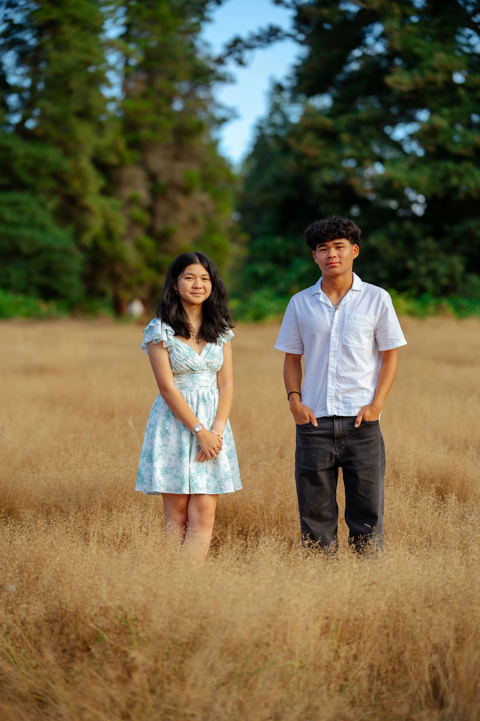 Siblings standing together in a late-summer field
