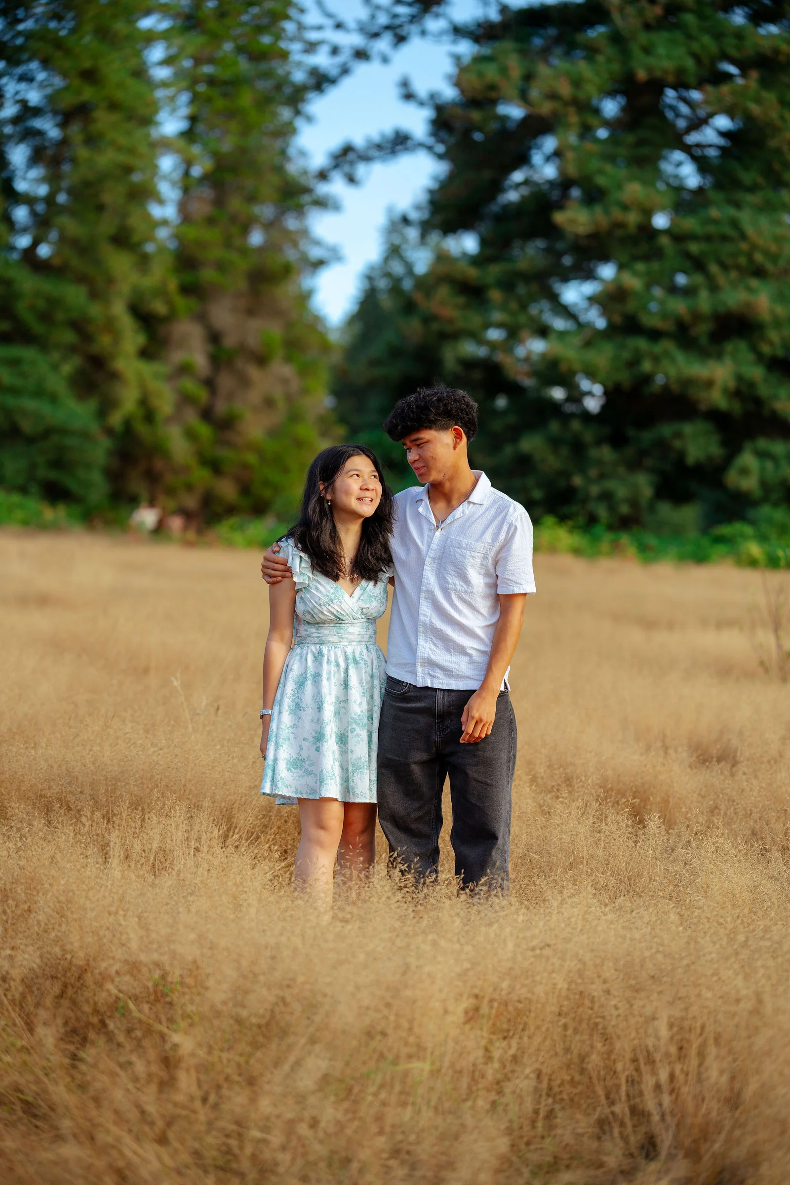 Siblings in a wide open field at the end of summer