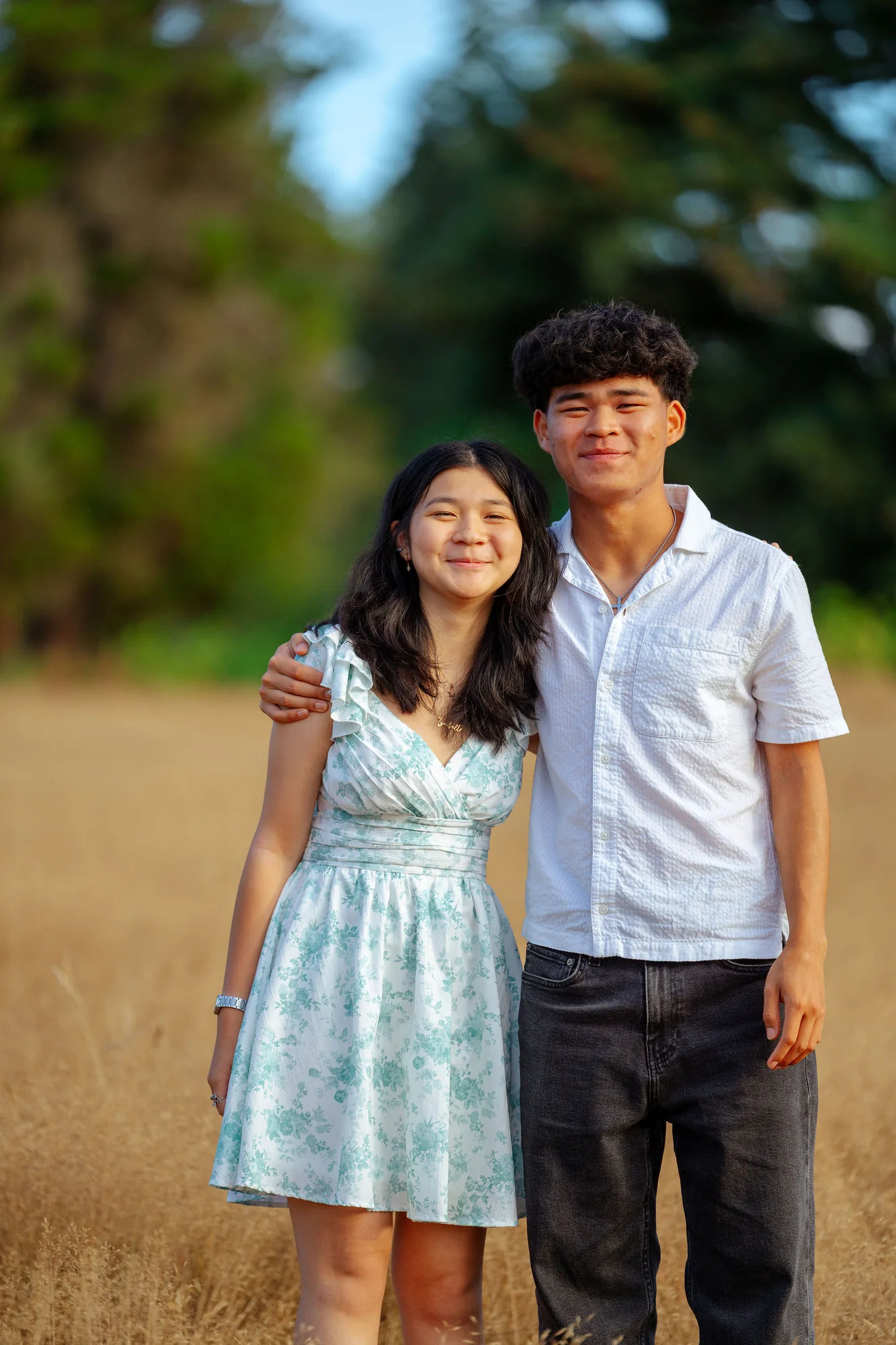 Siblings together in a golden field at the end of summer