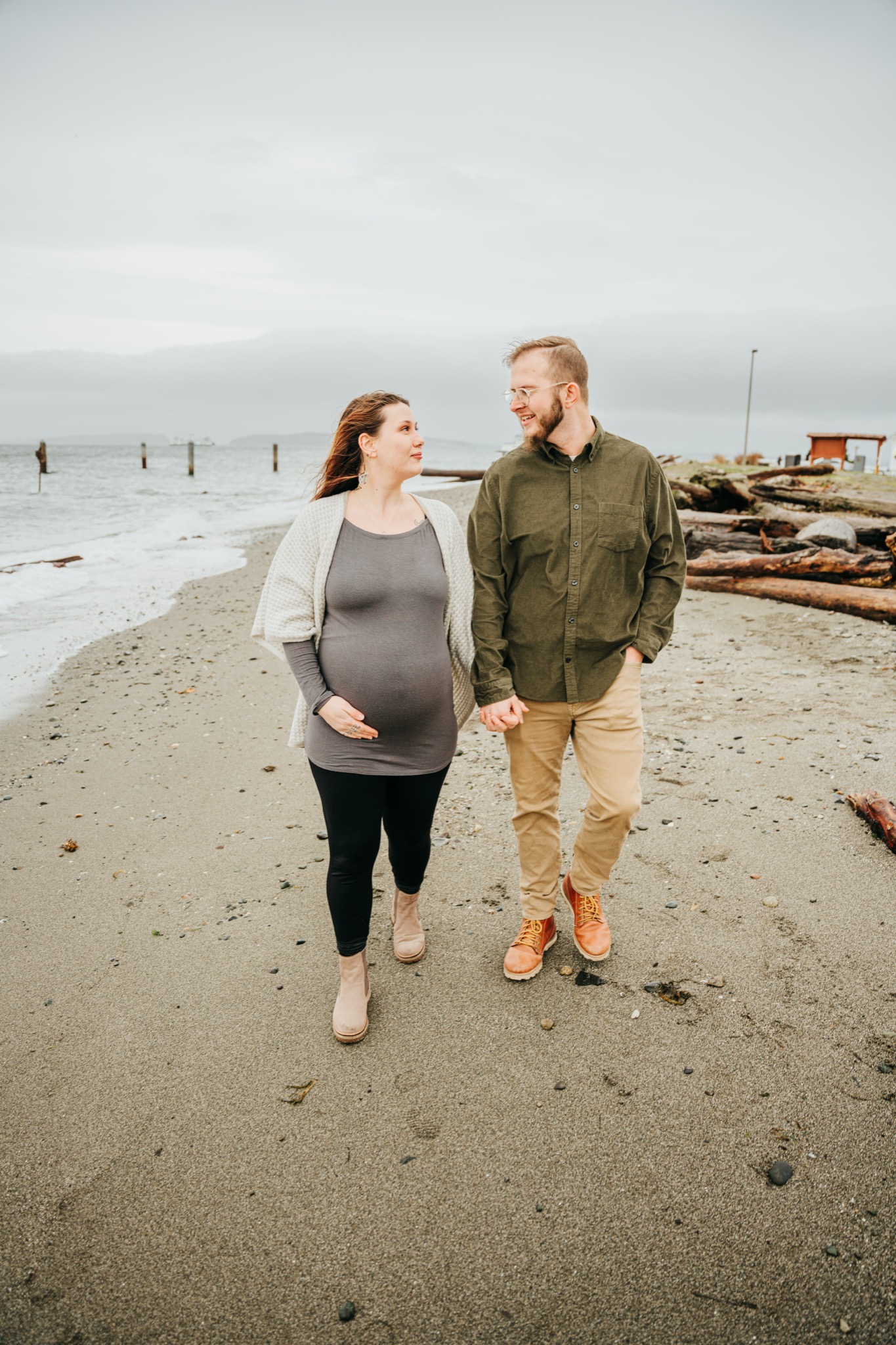 Engaged couple walking along the beach during Edmonds engagement photo session