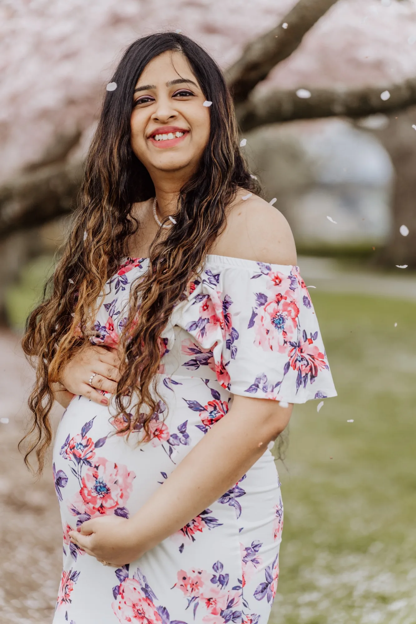 Expecting mother smiling under cherry blossoms in Snohomish County maternity session