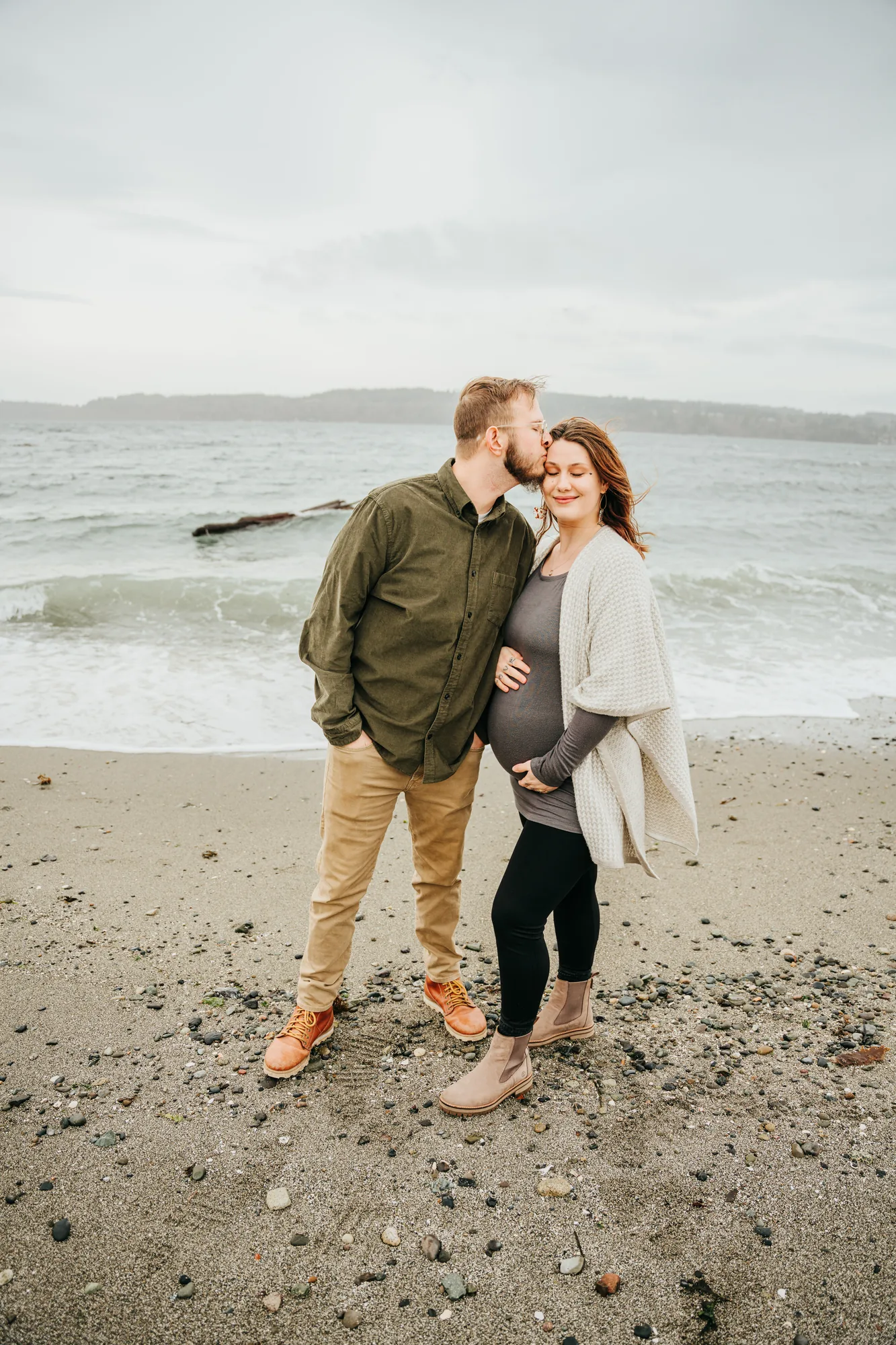 Expecting couple sharing a kiss at beach during Snohomish County maternity session