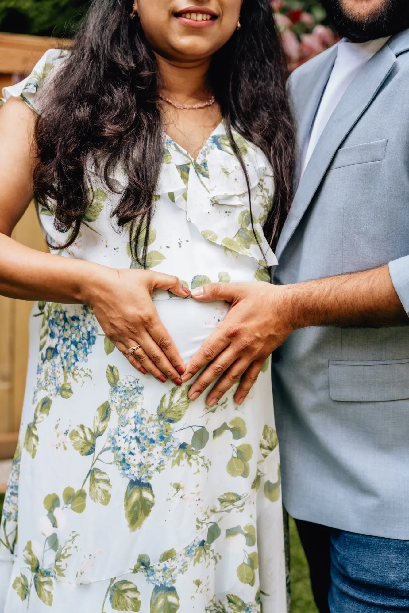 Expecting parents making heart shape with hands over baby bump in Snohomish County