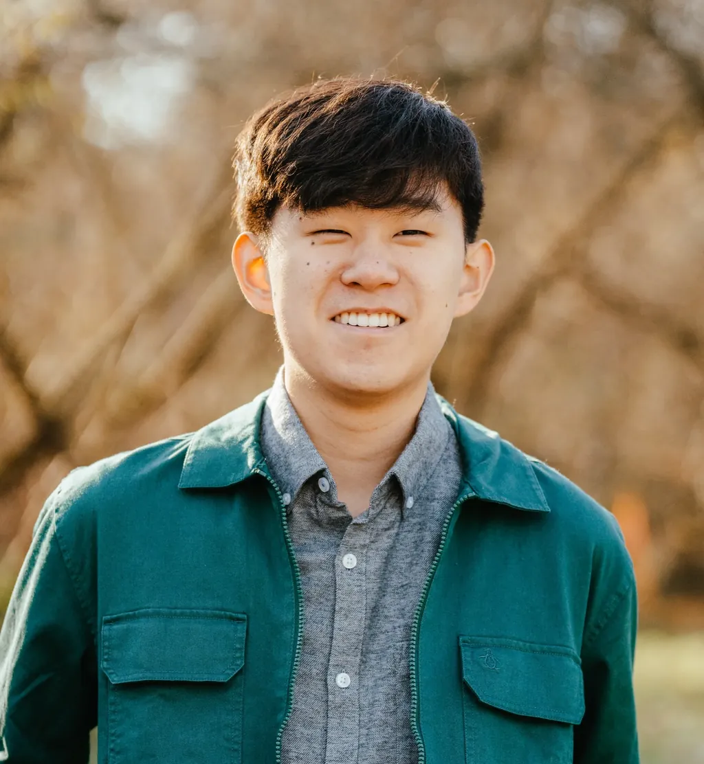 Senior in a teal jacket smiling on a fall afternoon in Lake Stevens