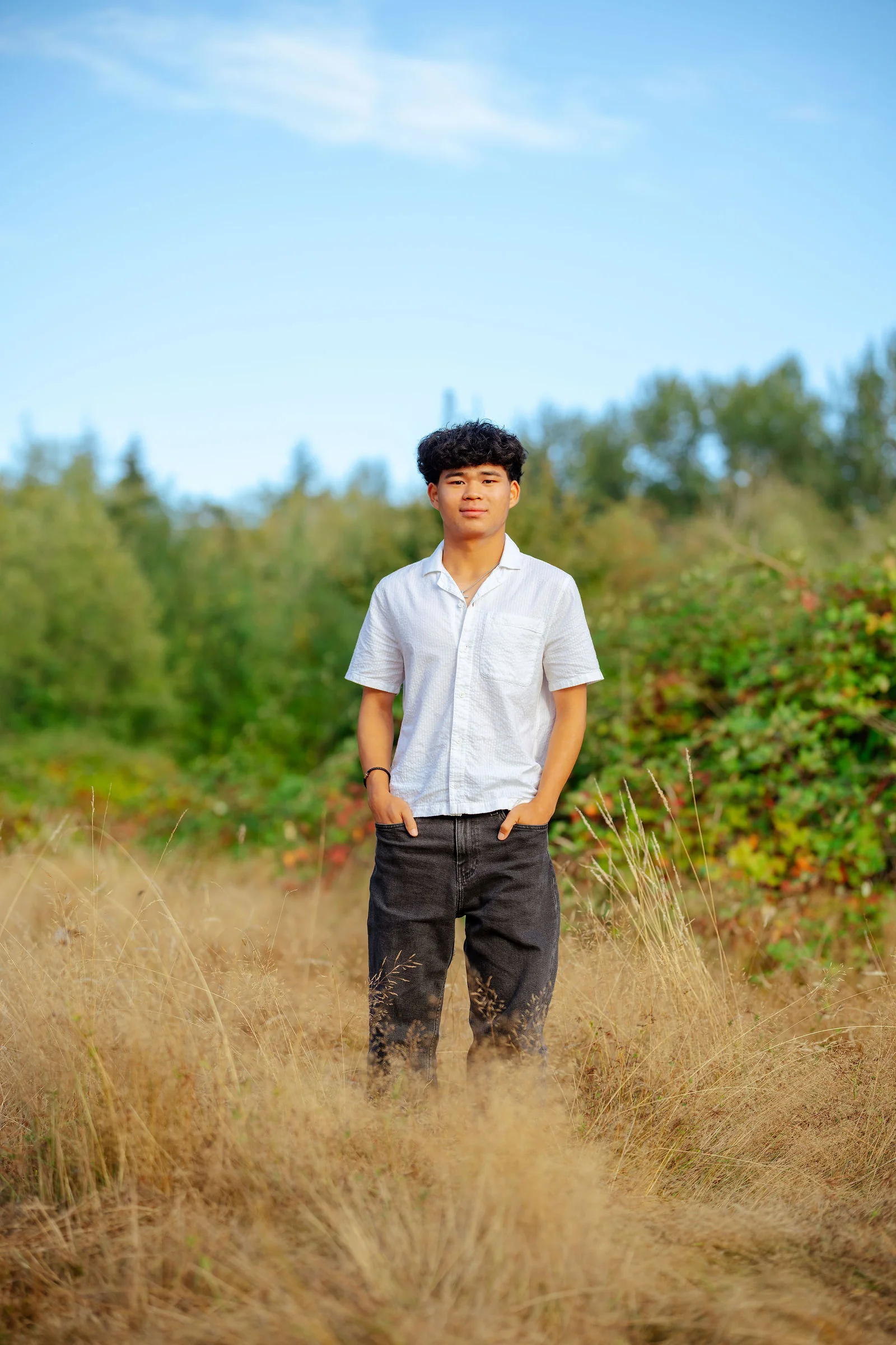 Senior in a field beneath a clear blue sky