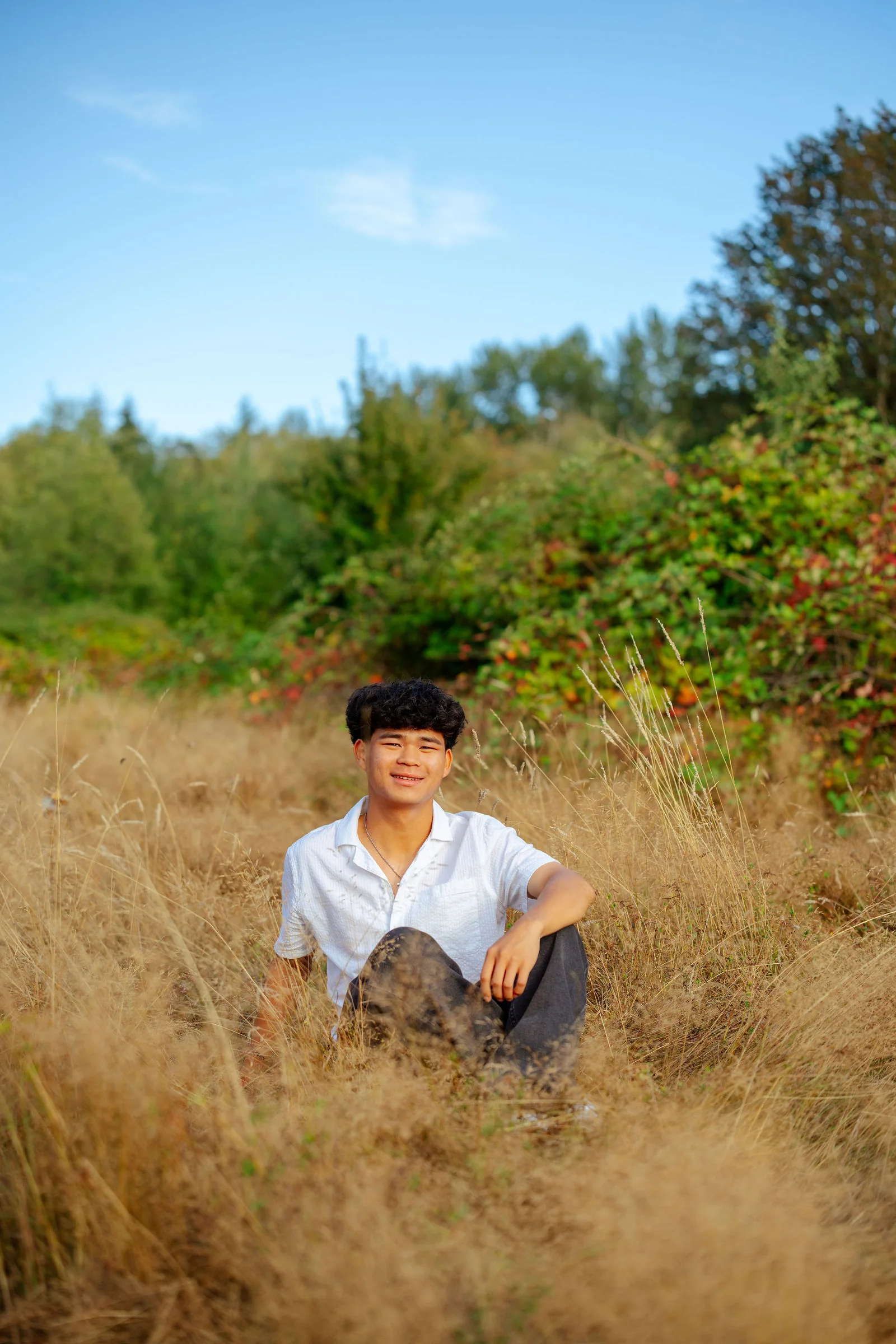 Senior sitting in tall dry grass