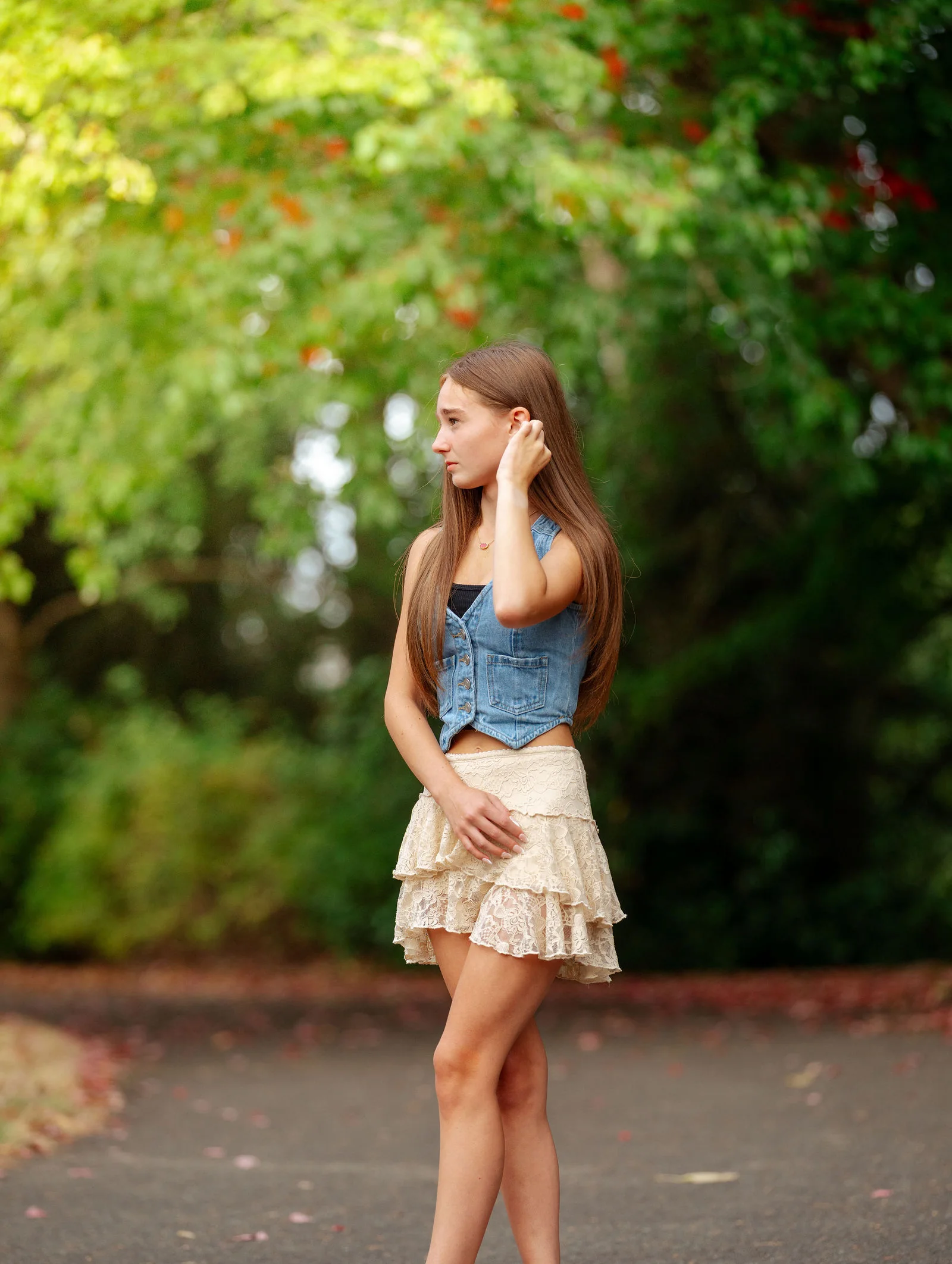 Senior glancing back beneath a green canopy