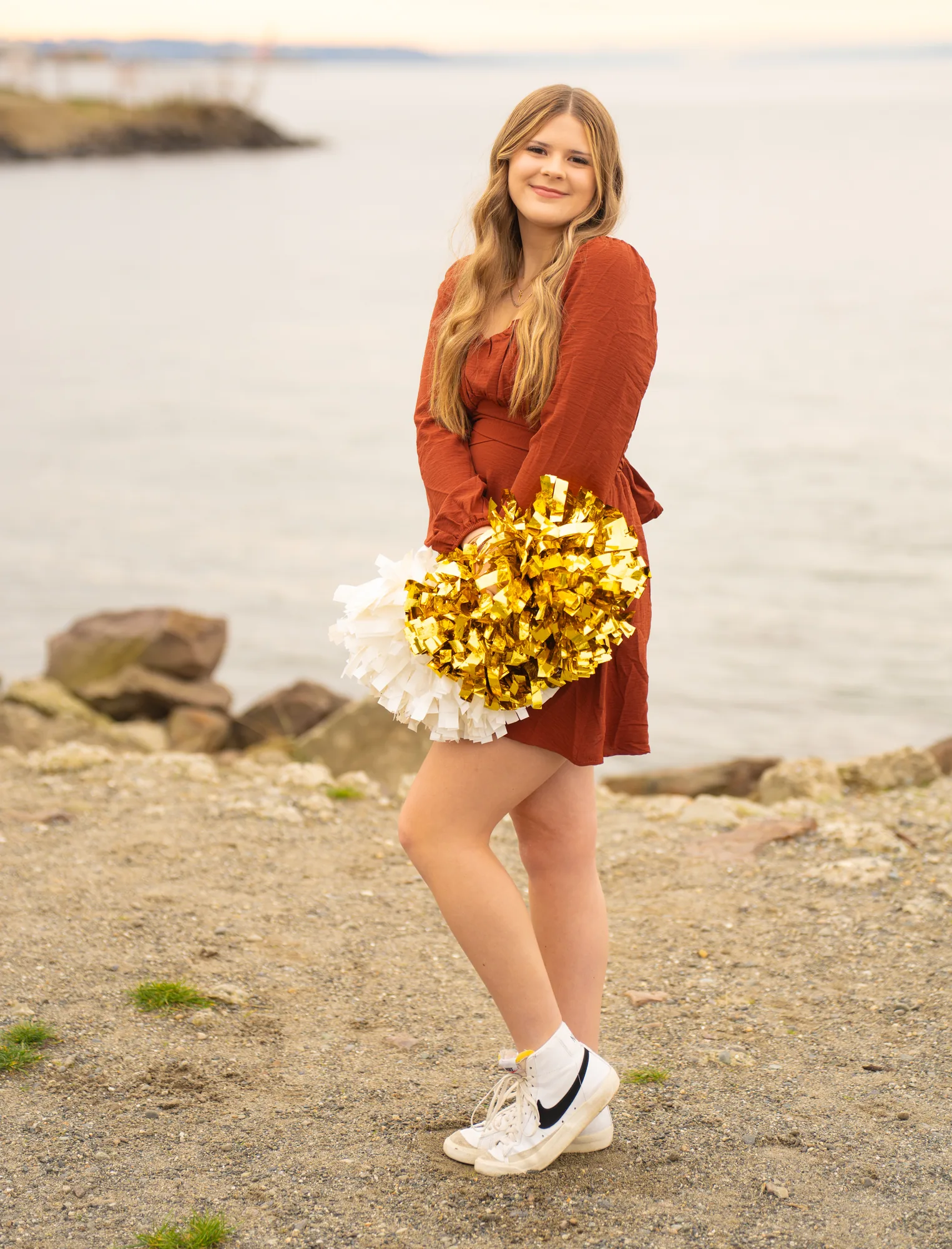 Senior portrait cheer uniform with pompoms on beach in Snohomish County
