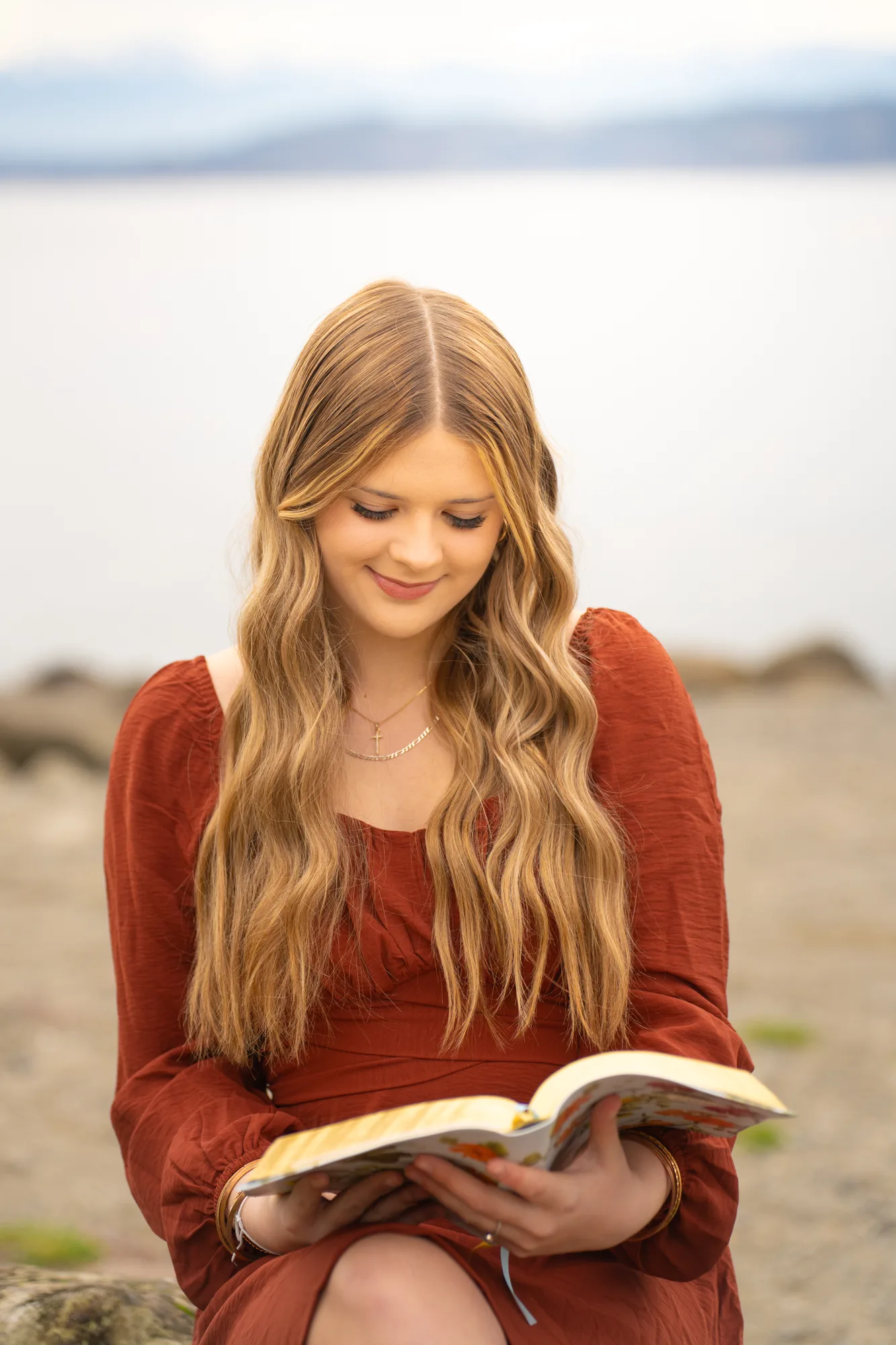 Senior girl reading book at beach during Snohomish County portrait session