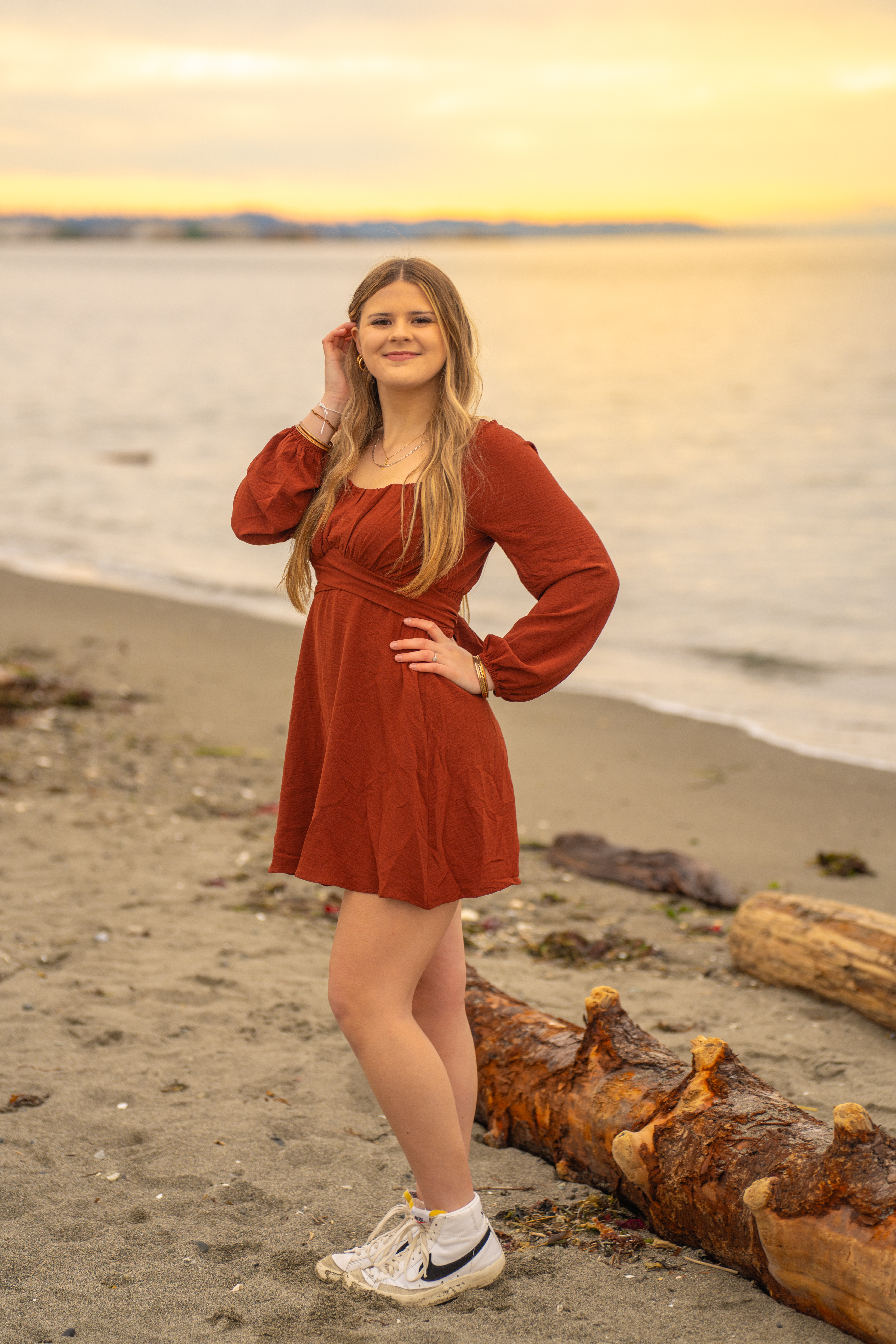 Senior girl in rust dress at beach during sunset in Snohomish County