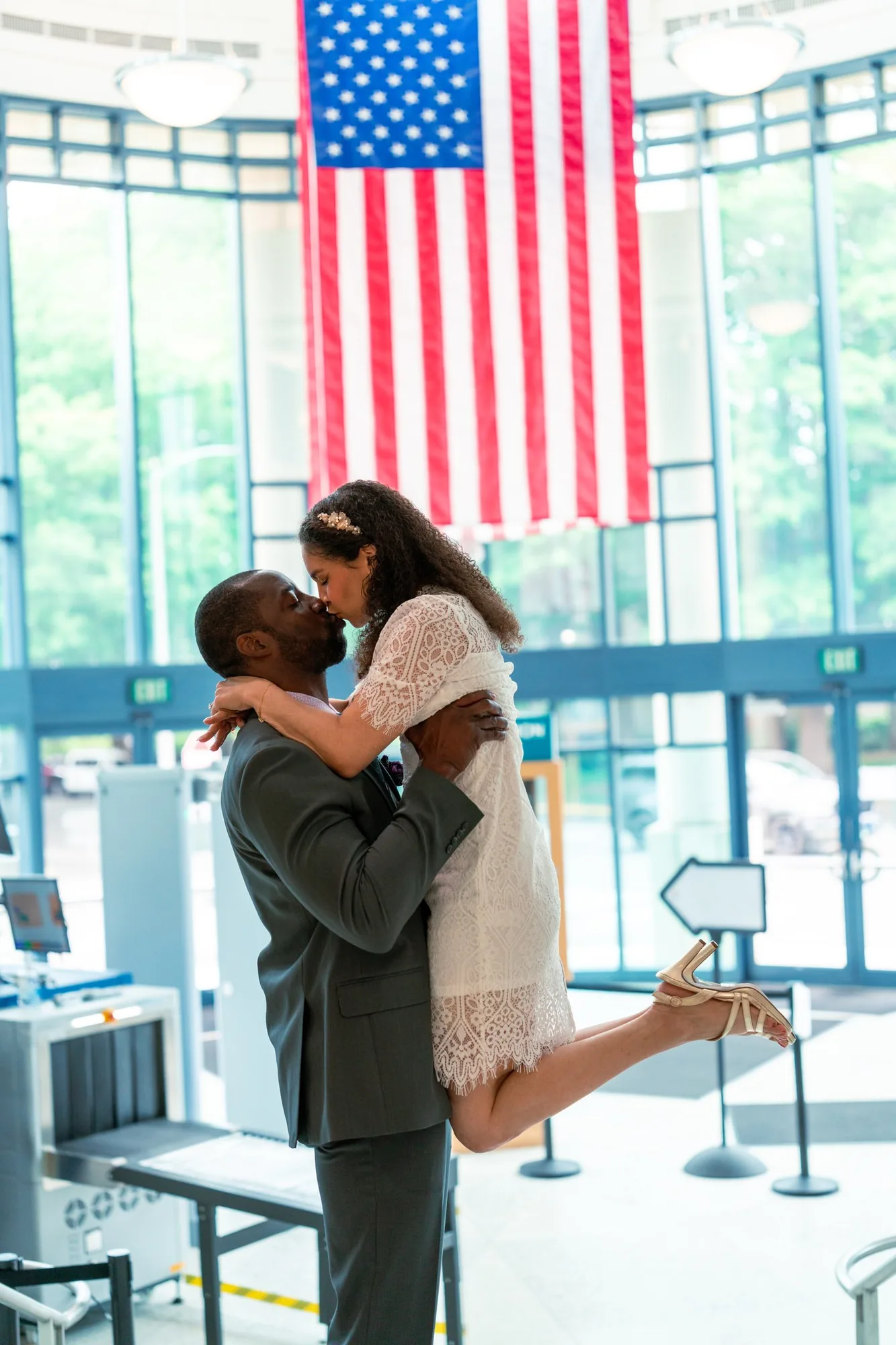 Groom lifting his bride for a kiss in the courthouse lobby at their Washington elopement