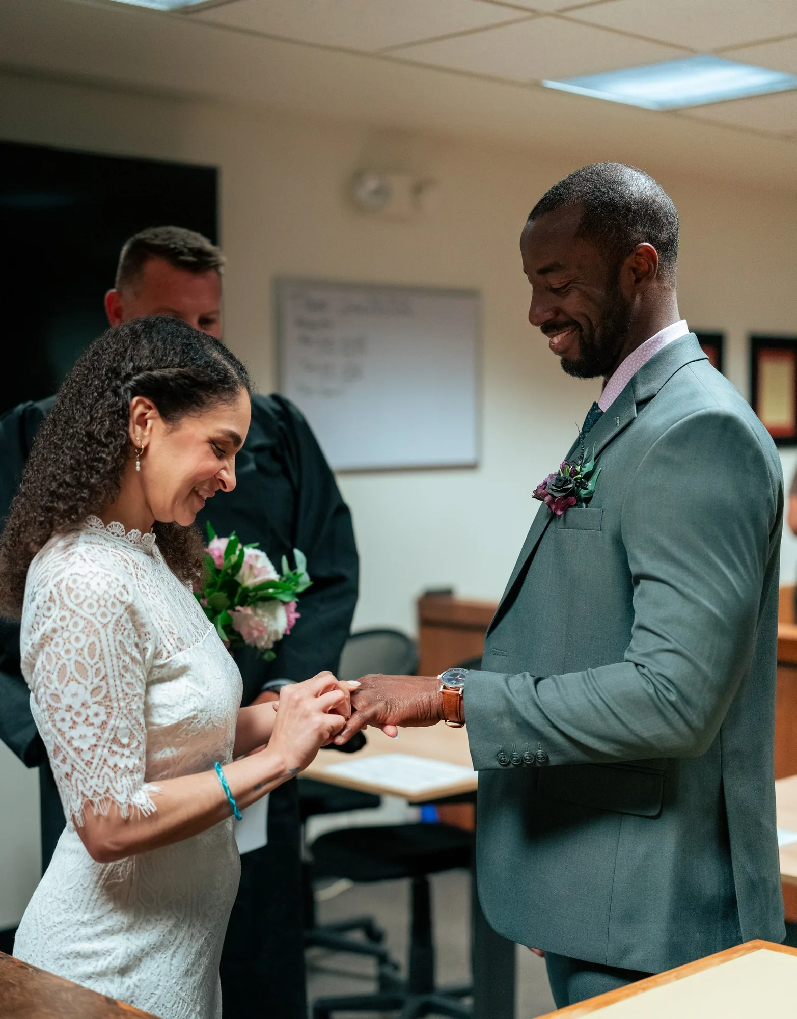 Bride and groom exchanging rings before the judge at their intimate courthouse wedding