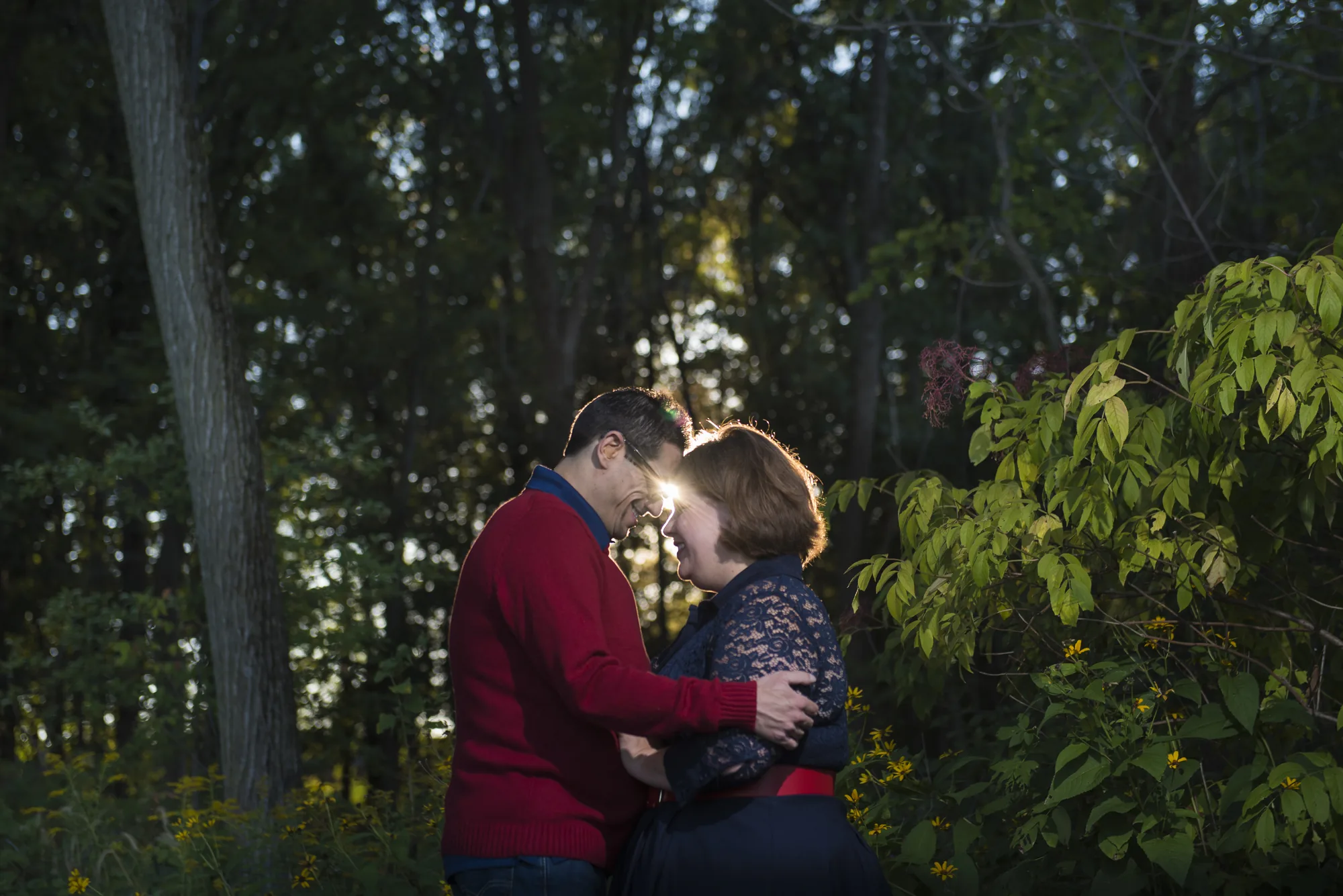 Engaged couple embracing in forest at sunset in Snohomish County