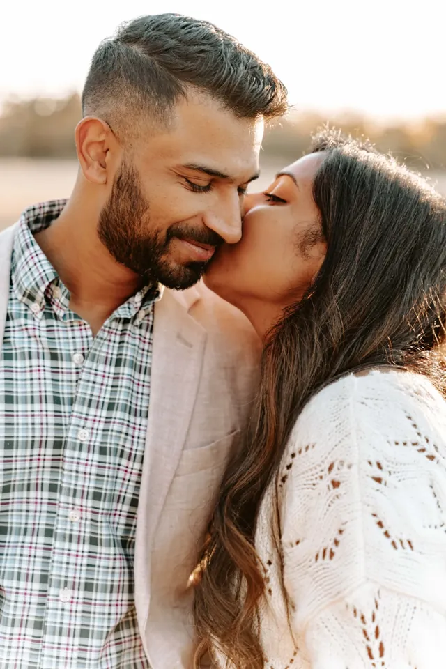 Engaged couple kissing at golden hour: PNW outfit ideas