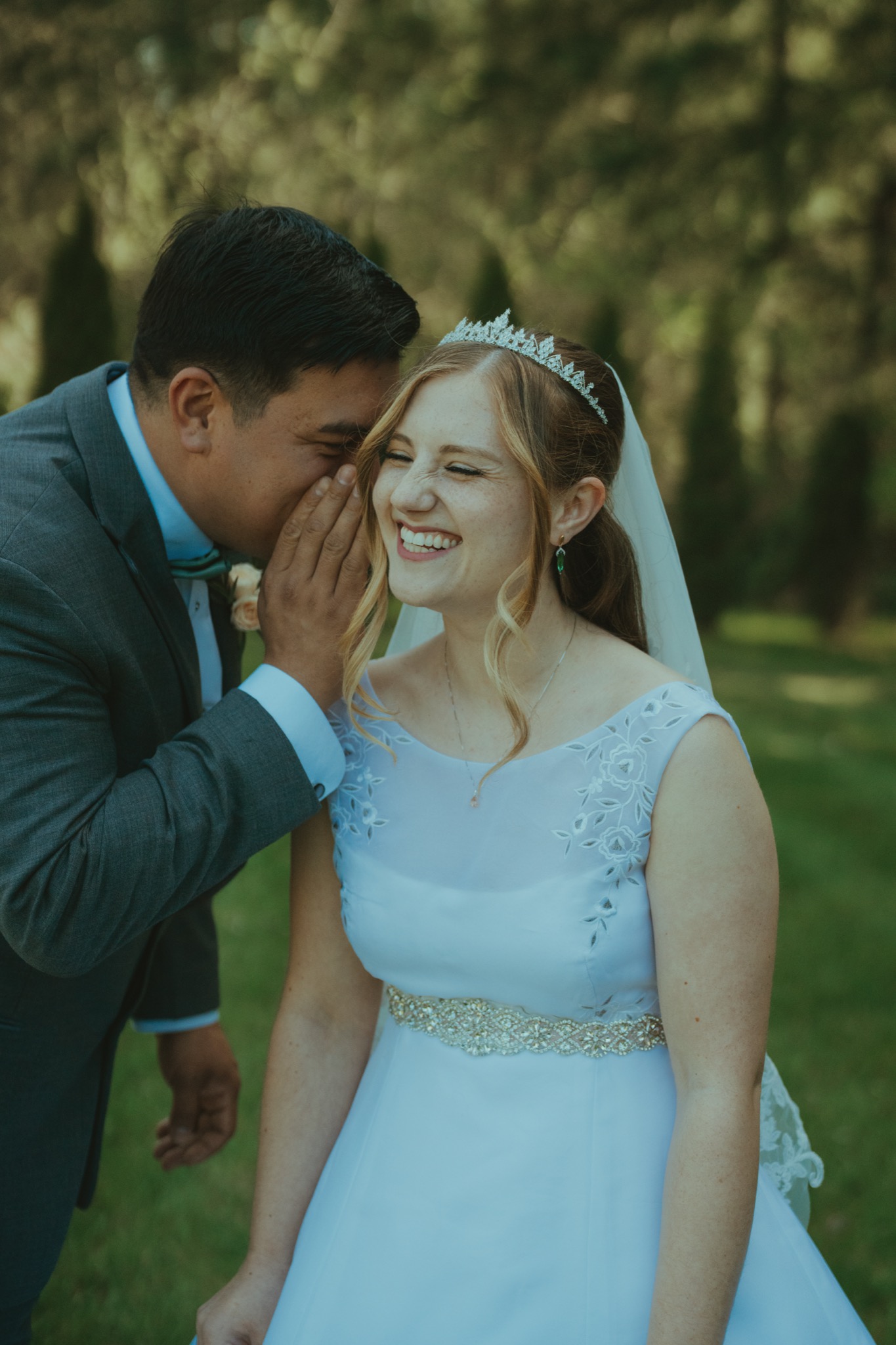 Groom whispering into bride's ear at Snohomish County wedding