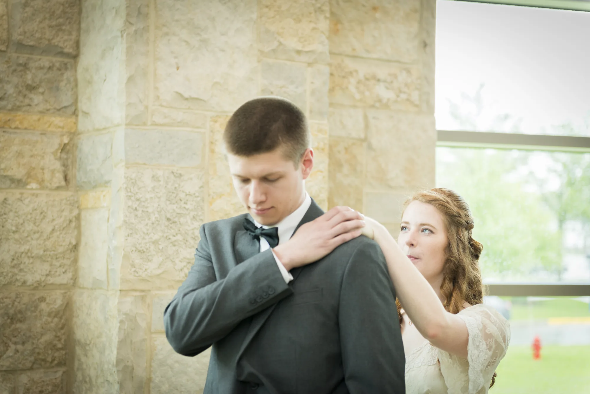 Bride pinning boutonniere on groom at Snohomish County wedding