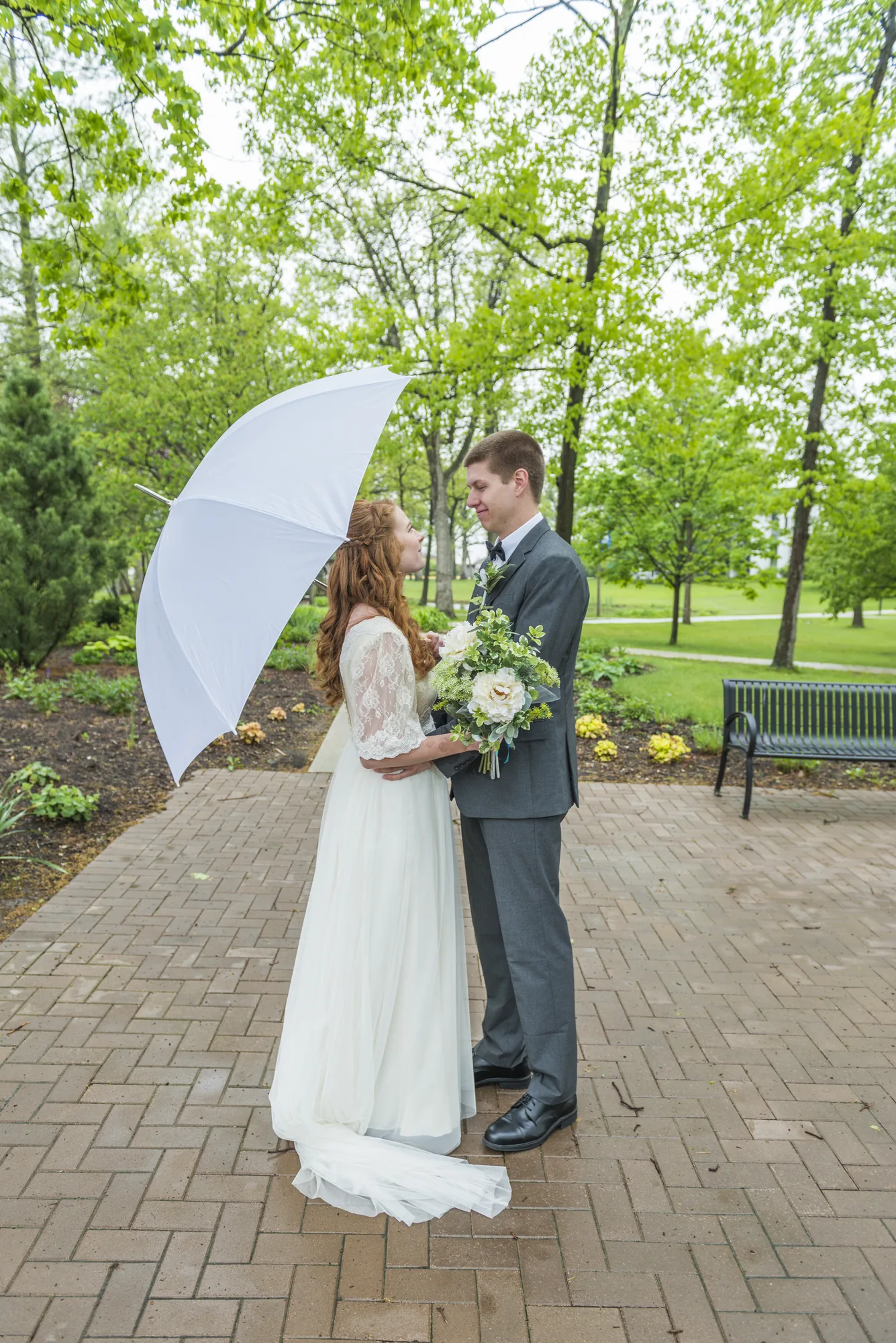 Wedding couple under white umbrella in garden at Snohomish County