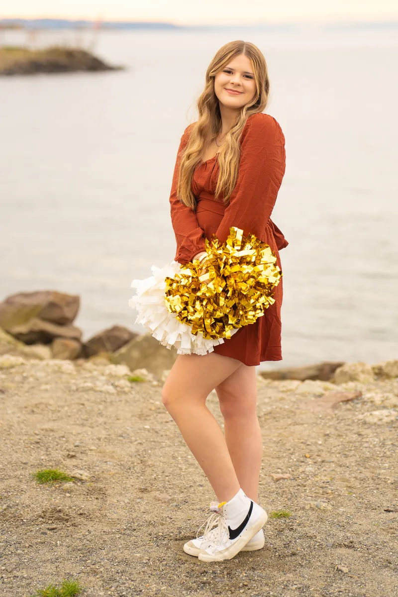 Cheerleader senior portrait with pompoms on the beach