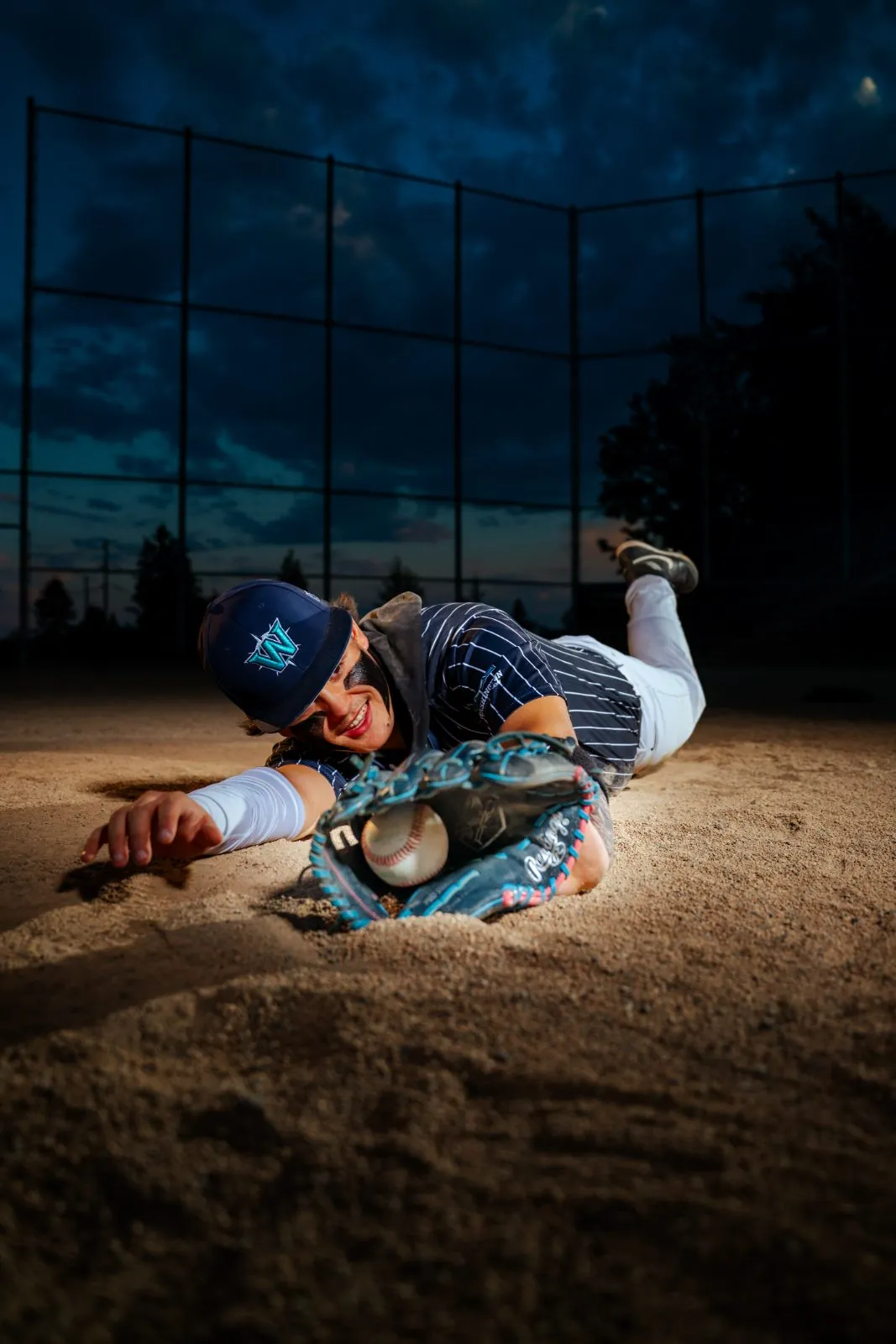 Senior athlete sliding into the dirt at dusk during a Snohomish County sports session