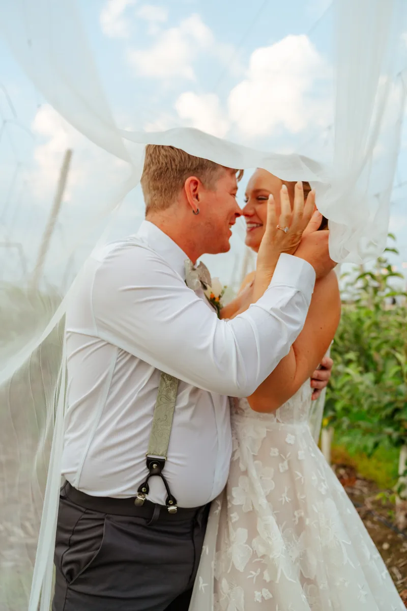 Bride and groom beneath the veil in an orchard — Snohomish County wedding